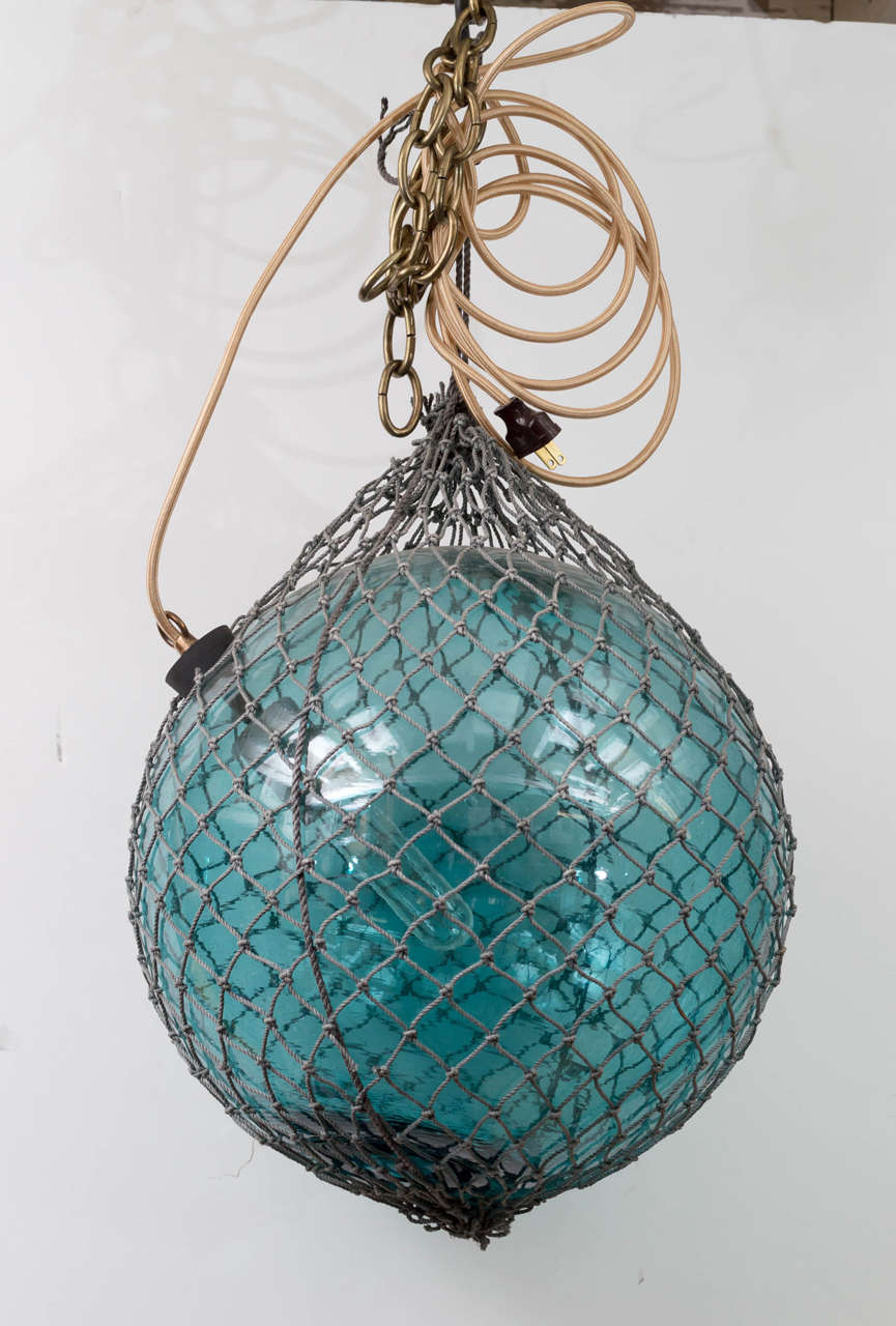 Unique in color and hand blown Japanese fishing float with original netting. Wire with one socket and gold fabric cord.