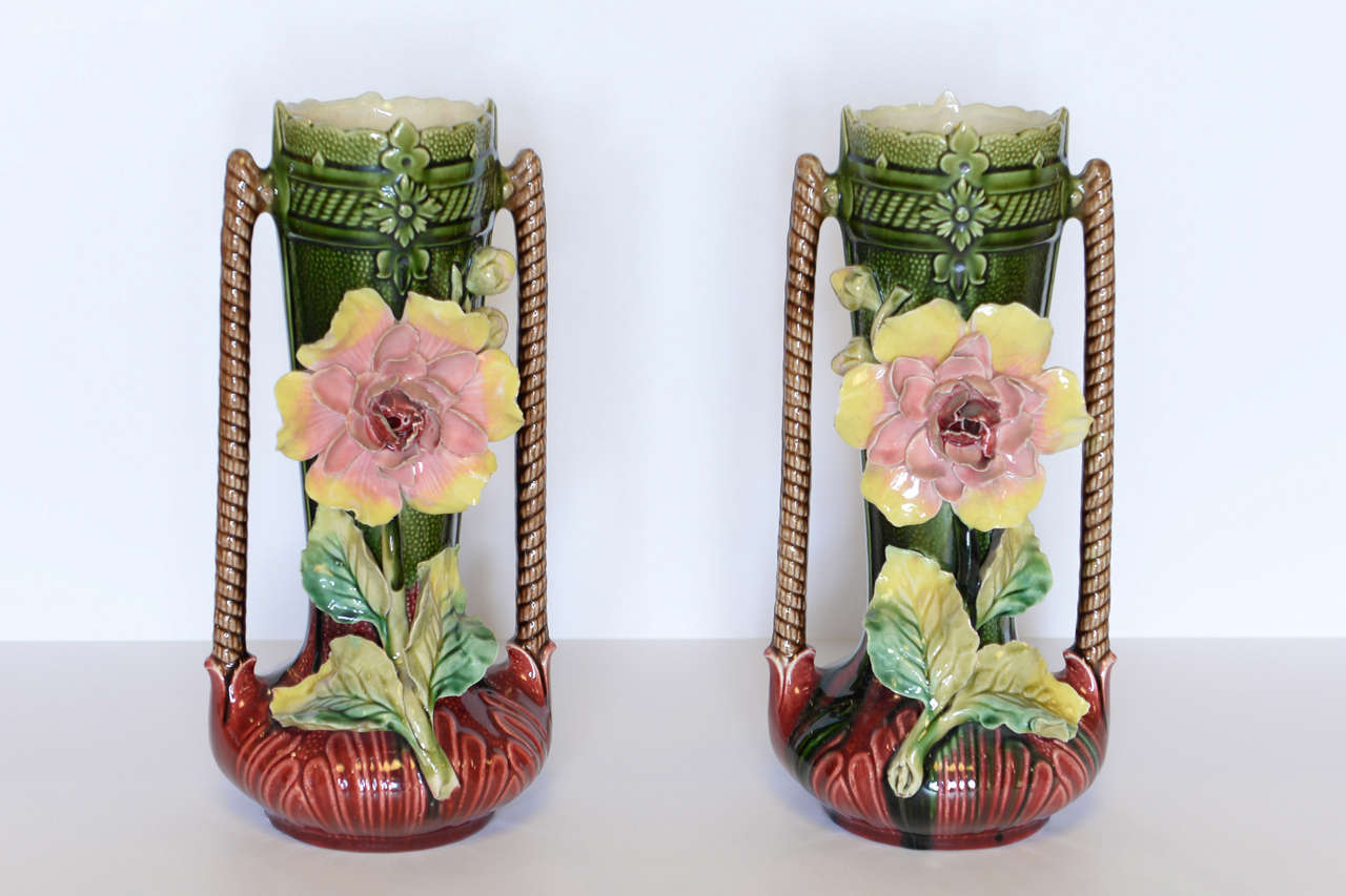 Pair of  French Majolica Vases with Flowers, Circa 1940
The unusual coloring of this pair of majolica vases is what makes them unique. They are a lovely blending of burgundy and green highlighted with the pale yellow flower.
