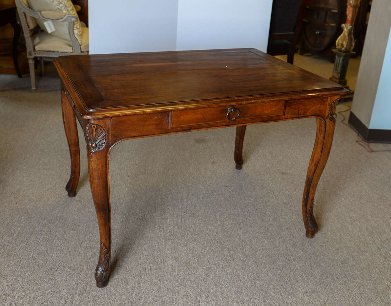 This pretty walnut table can serve any number of purposes.  It is finished all all sides so it could be used as a center table and since it has a drawer on each side and ample leg room, it would be a good candidate for a  game table. Each gacefully