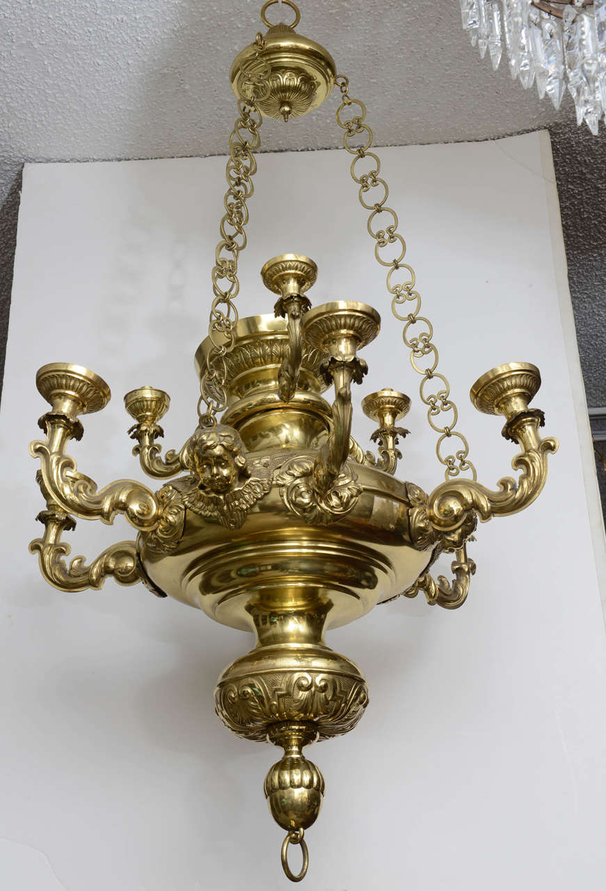 Baroque in style, this fixture is large and impressive.  It may have hung in a religious  house of worship.  It has a total nine arms, six on the lower section separated by a cherub and three on the upper tier.  This fixture is not wired but could