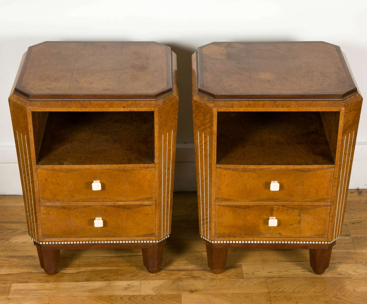 Rare and precious pair of nightstands by Paul Follot (1877-1942), trapezoidal prism shape with two opening top drawers summoned by a niche, in veneer and marquetry. Marquetry on all faces, carved mahogany feet.

This piece of furniture is
