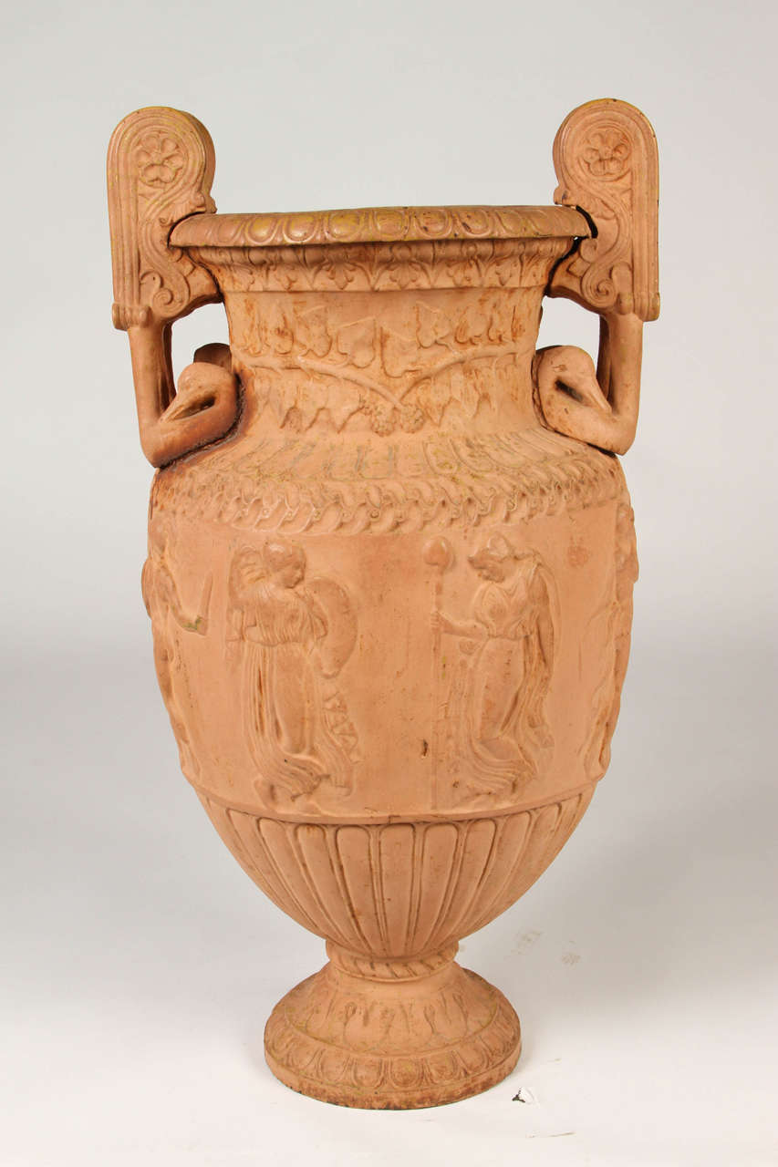 This is a neoclassical iron urn after the Townley Vase. The ovoid vase has volute handles and wonderful delicate details. 
It's unique terra-cotta coloring and large scale make it a wonderful focal point both indoors and out.