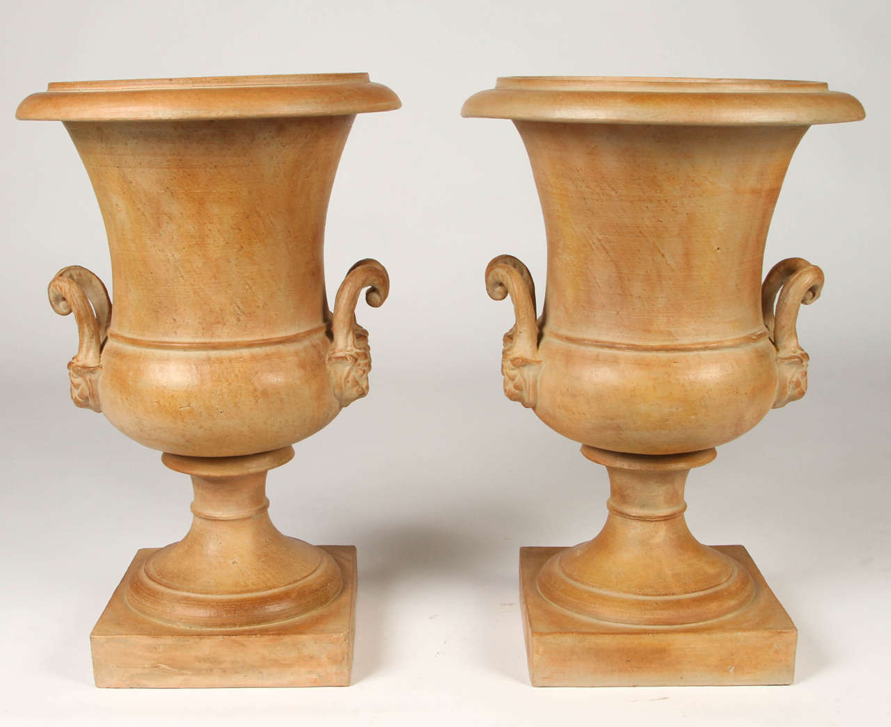 This lovely pair of terracotta urns perfectly exemplify the neoclassical style. They would be a warm addition to any space, indoors or out.