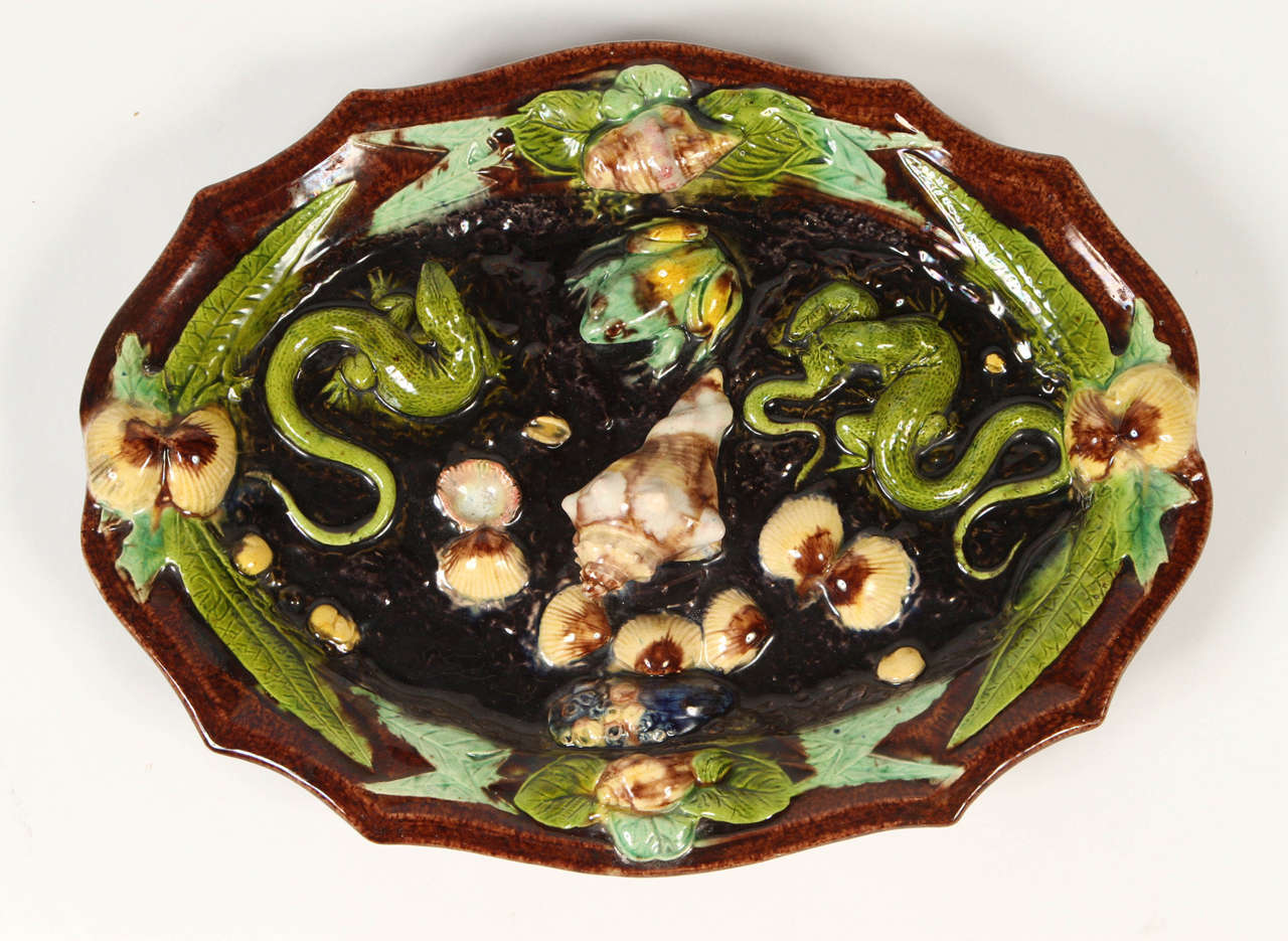 Pair of French Palissy Ware majolica oval plates from the 19th century. The center of the plates are occupied by naturalistically modelled lizards and frogs  all resting on a bed of leaves and shells. Great color and fantastic trompe l'oeil detail.