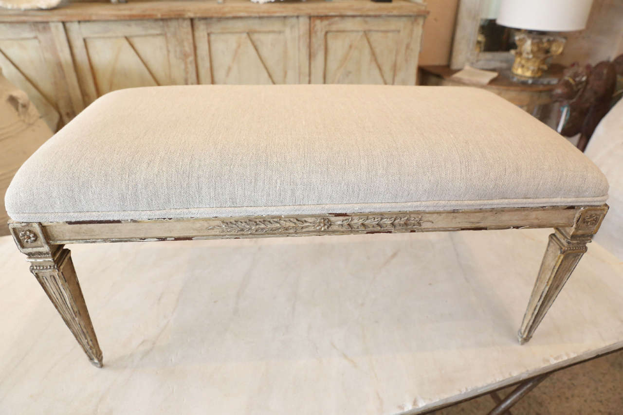 Carved and gilded Louis XVI style bench with plaster decoration and tapered legs.