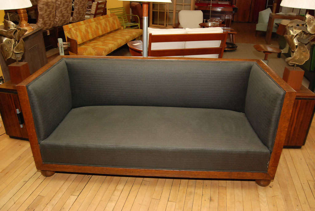 American Edwardian sofa with exposed oak framing and ball feet. Newly upholstered in matte -black wool herring bone fabric, with new hand-tied spring seat.