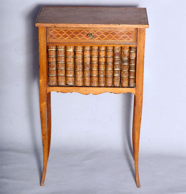 Cabinet with false front, having its top and sides decorated in geometric parquetry; locking hinged top over false drawer and row of old book spines, raised on fine cabriole legs.