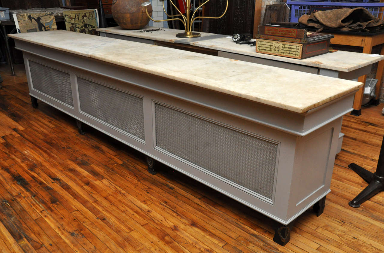 An American country store counter with a marble top and newer back drawers.