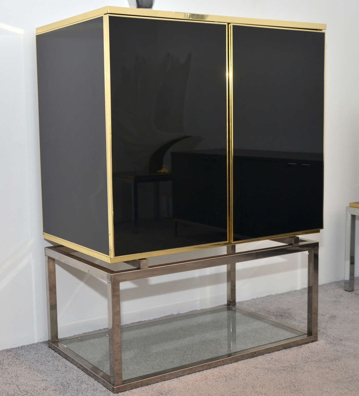 1970s cabinet by Maison Jansen with base in chromed steel and glass; structure in black lacquer and brass; two new interior glass shelves.