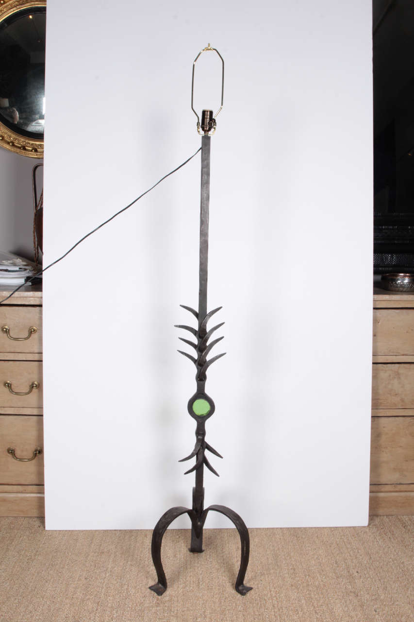Pair of French hand-forged wrought iron floor lamps with green glass eye (can be sold separately.)