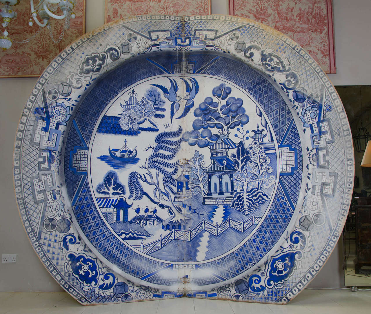 Extraordinary screen or wall hanging, hand painted on canvas mounted on a wood frame, in the form of a huge Willow Patterned Plate. It is hinged in the middle and has pull out supports. It was used by the theatrical seaside touring company, Foi de