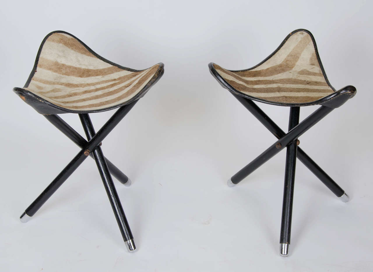 Pair of French Safari Stools with nice zebra hide seats. The stools fold for transportation.