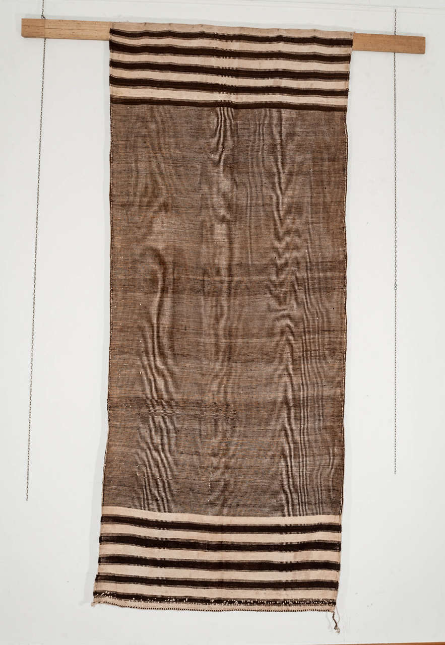 A rare and usual Berber flat-weave originating from the Moroccan High Atlas region. The textured ivory/mocha background is obtained through a complex flat-weave technique of interlocking wefts. A very elegant piece that could work both in a