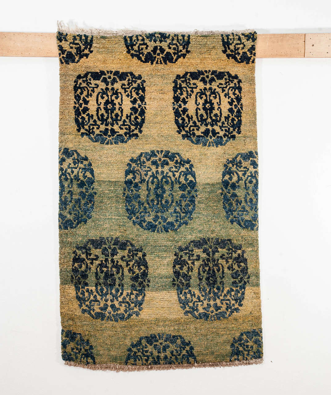 A rare Tibetan rug in the khaden format distinguished by a sea green background decorated by an all-over infinite repeat pattern of roundels composed of conjoined lotus flowers.
The silky quality of the Himalayan wool and the excellent condition