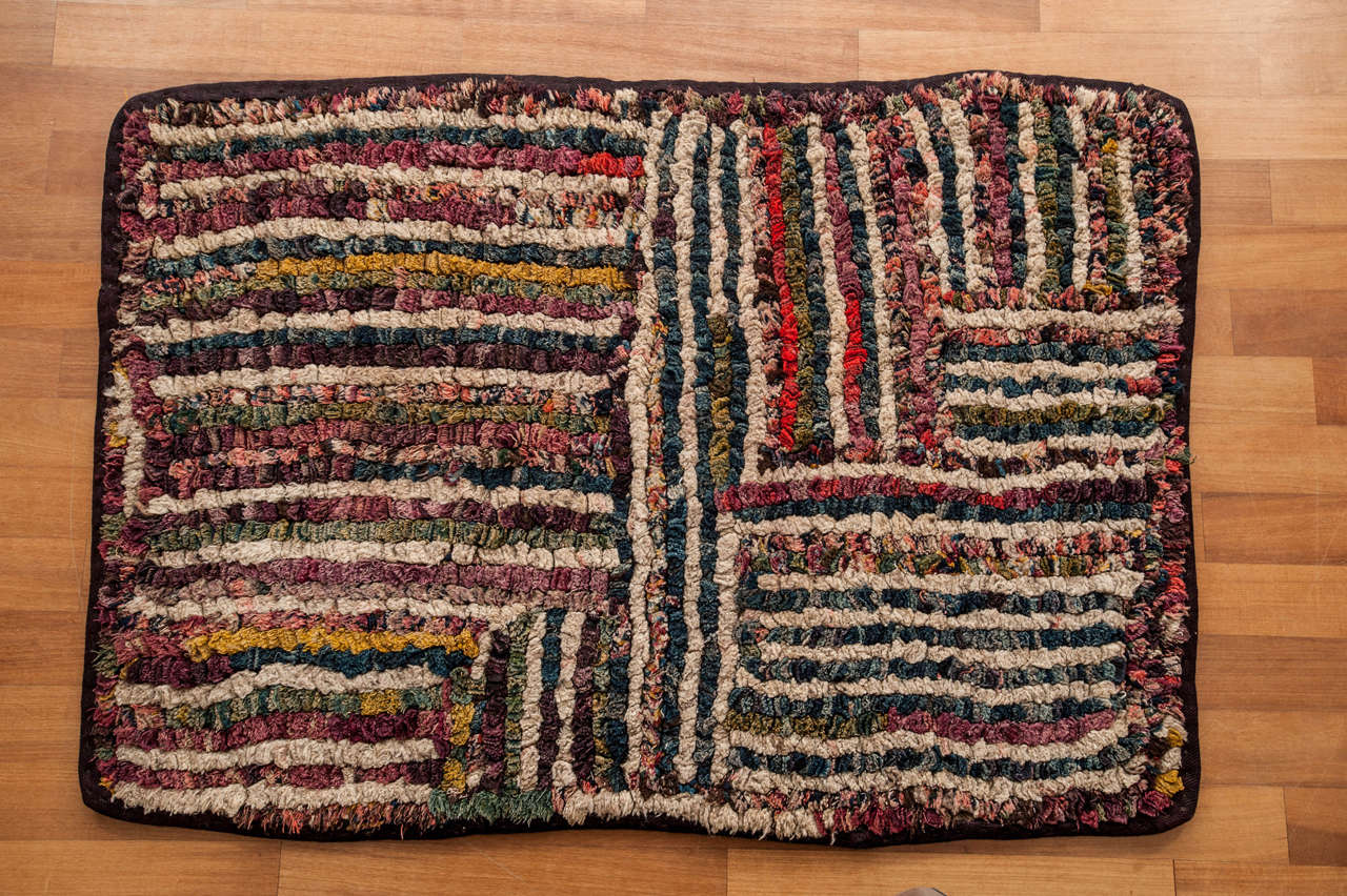 A rare and unusual Tibetan rug woven with the wool yarn obtained by unravelling the so-called 'Nambu' skirts, which are typically decorated by multicolored stripes. The unravelled yarn is arranged by colour and then hand-stitched onto an indigo dyed