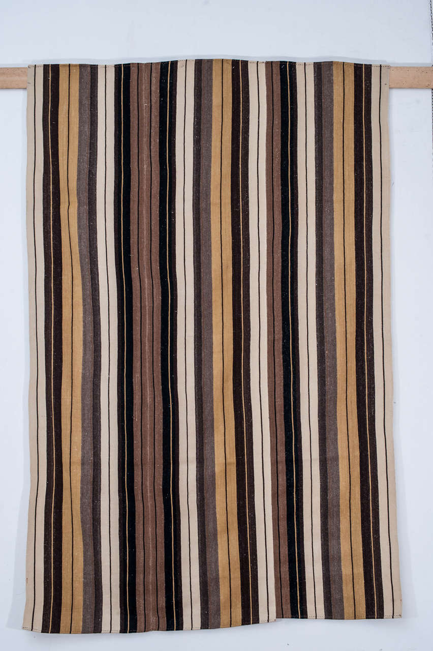 Un tissage plat inhabituel de la région de Karapinar, en Anatolie centrale, décoré de bandes verticales dans les tons ivoire, gris, chameau, jaune et noir.