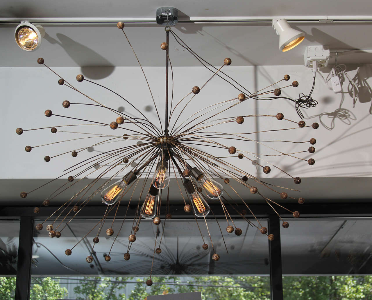 Sputnick style chandelier of rust metal with remnants of old white paint.
  