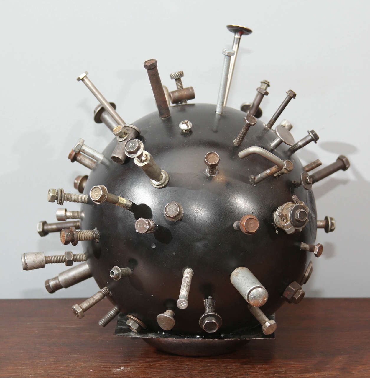 Bowling ball impaled artistically with assorted metal items
great piece of Folk Art for table or shelf.