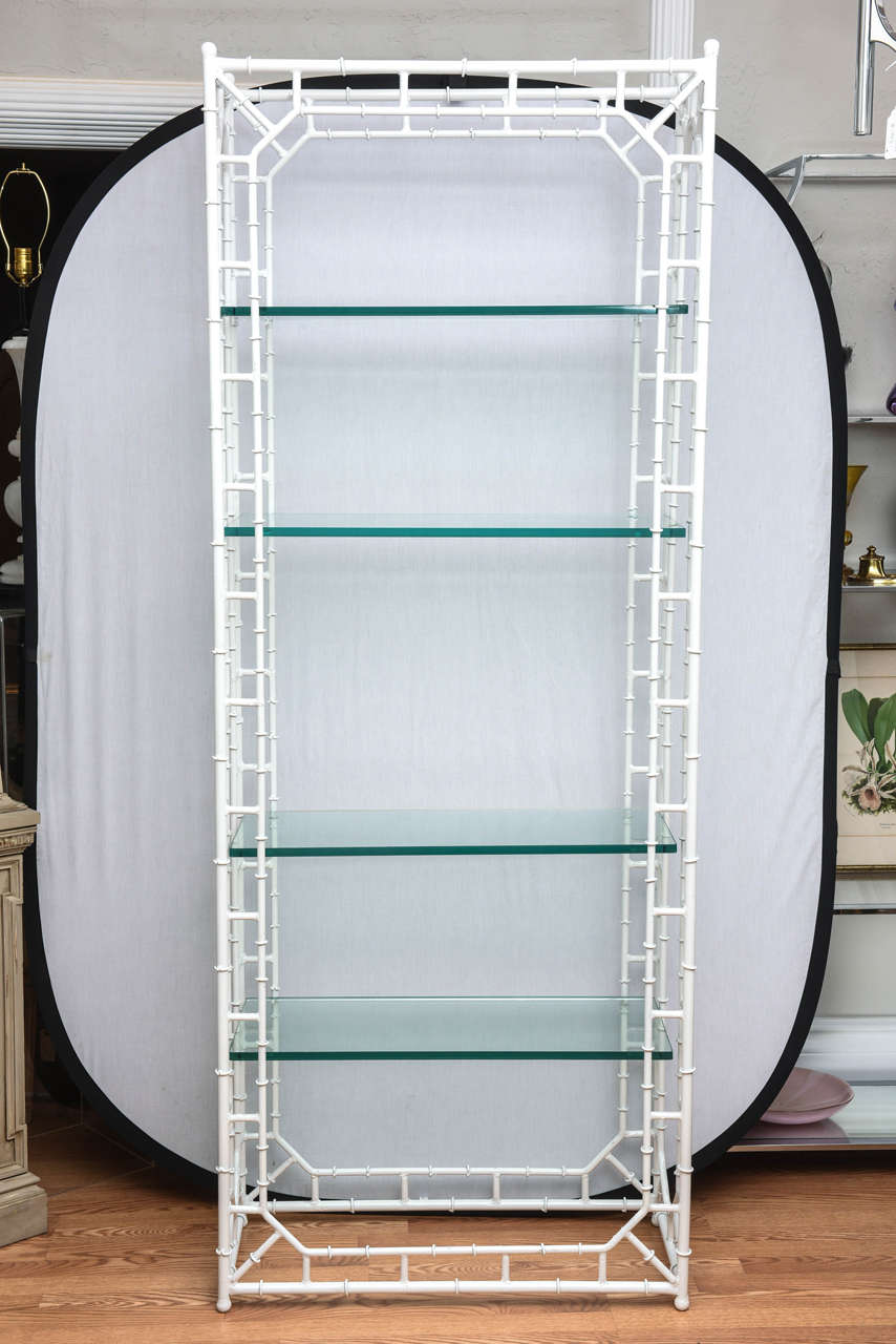 Pair of white faux bamboo étagerés with fretwork and five glass shelves.