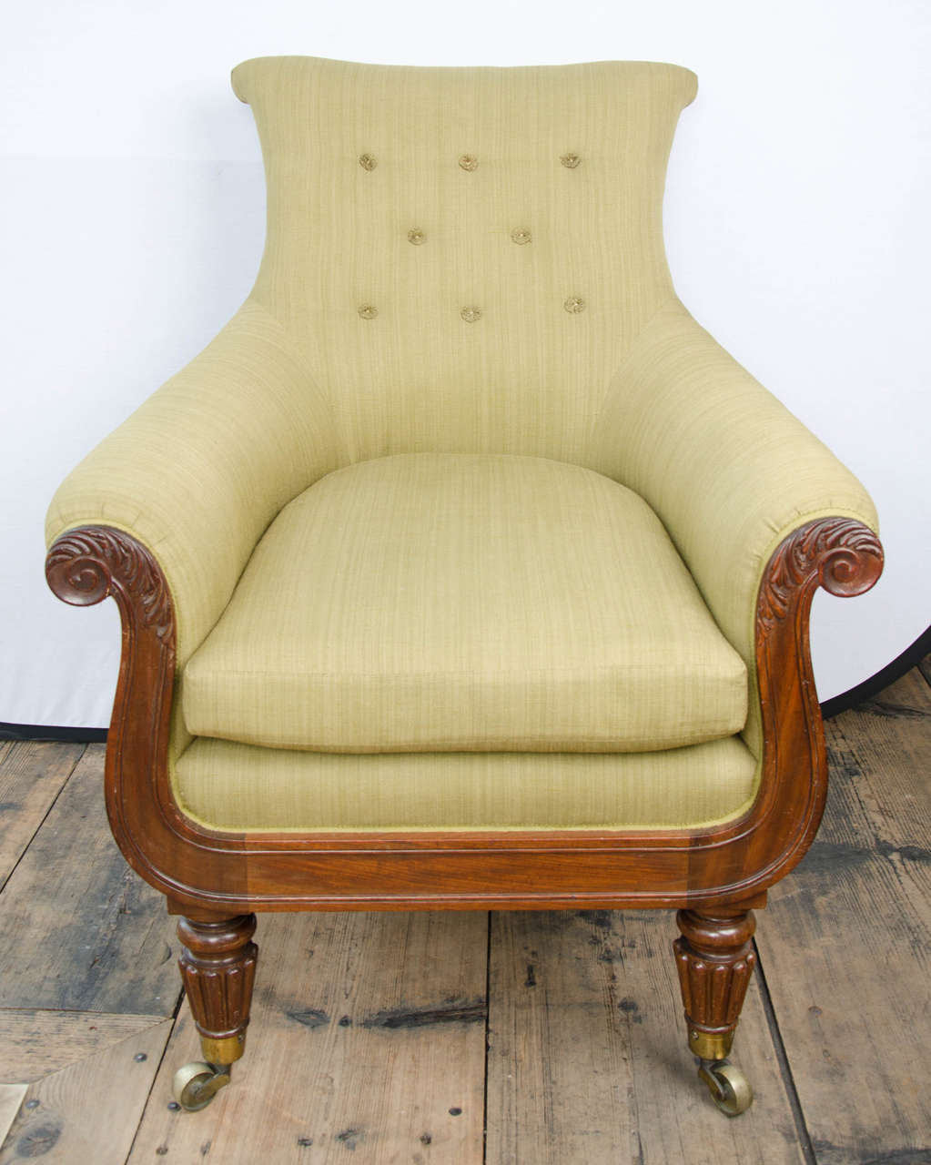 Regency mahogany library bergere in the manner of Gillows with outscrolled back and arms on reeded tapering legs.
