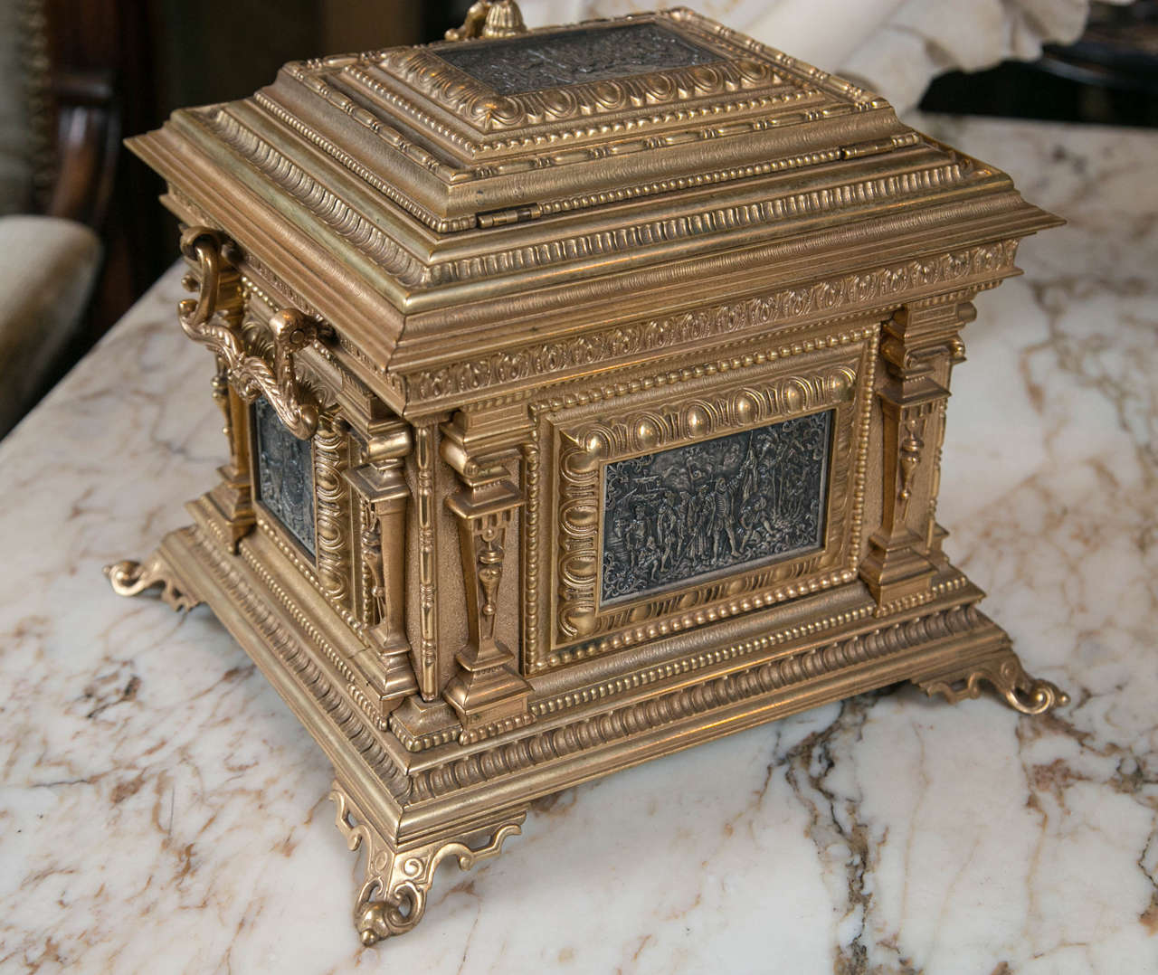 A very unusual casket form jewelry or trinket box, with lift top. It is lined in dark blue velvet. There is no lock and never had one. Tassel handle in bronze on lid..The  sides have  bale handles. On the top, front and back are what appear to be