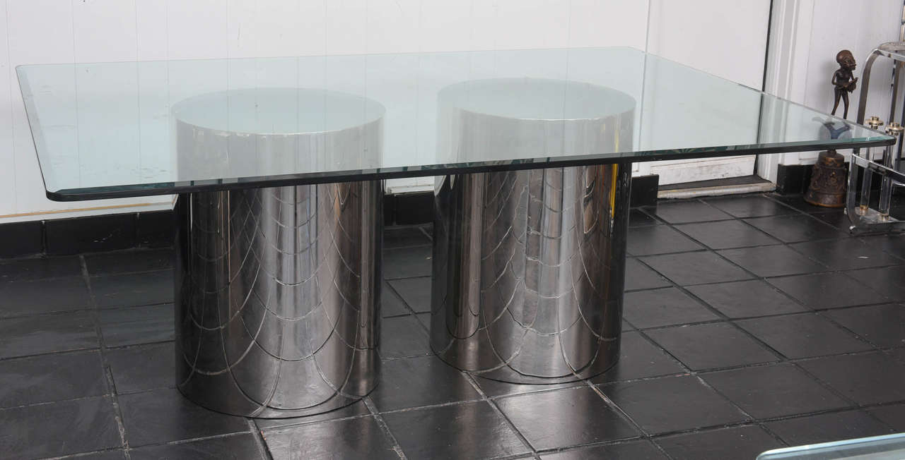 Polished steel Pedestal drums supporting thick beveled glass top, dining table.