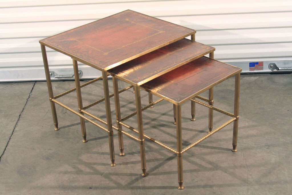 Very nice set of leather topped French Bagues style nesting tables with gilt tooled accents.