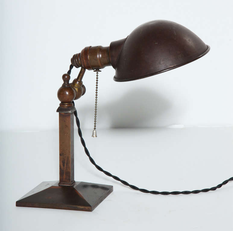 Early Adjustable Brass Pharmacy Desk Lamp, Bedside Lamp with Copper Clam Shell Shade. Featuring a rich dark patinated all Brass column, square pyramid base, adjustable adjustment nut and heavy duty fittings and 6D Copper clam shell shade. Standard