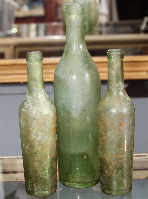 set of 3 distressed green bottles.   lovely as seen or used as vases