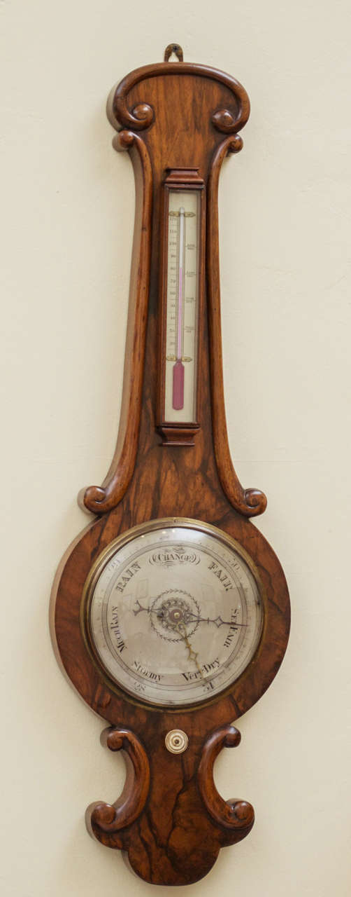 A gorgeous, English Victorian Walnut mercury wheel Barometer. The circular silvered wet-dry guage is beneath the Fahrenheit scale mercury thermometer.  There is a carved foliate spray to the scroll pediment. This Barometer retains its beautiful,