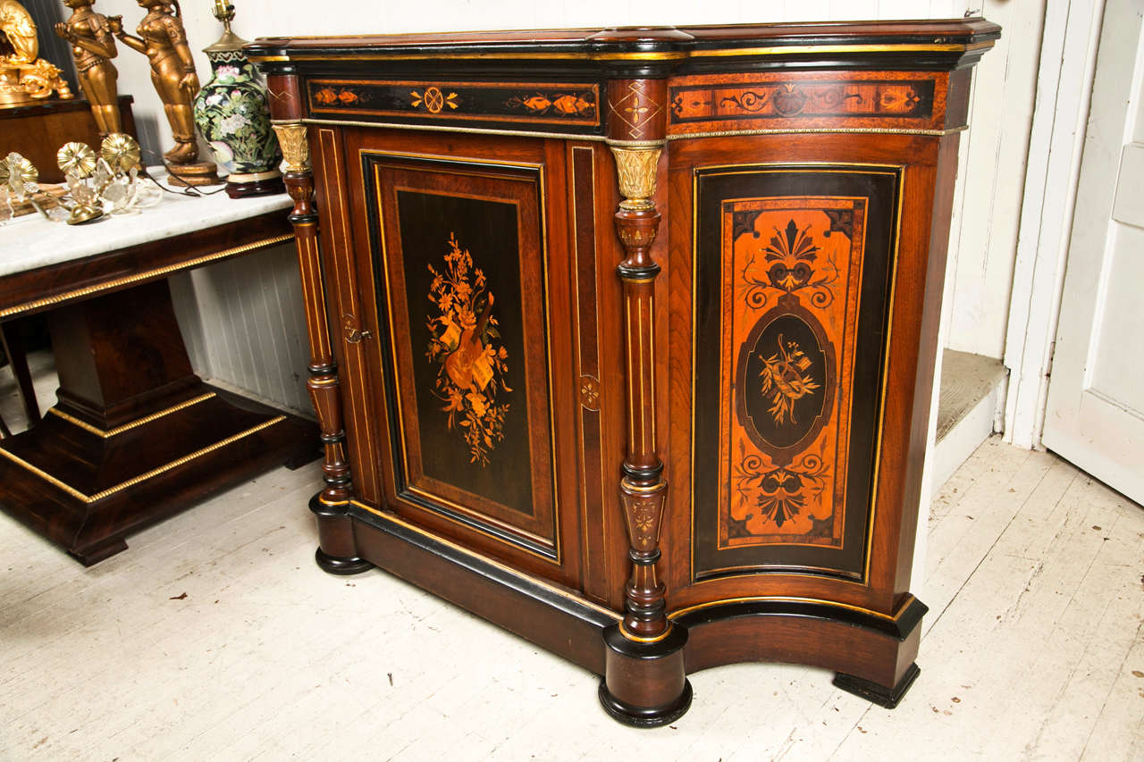 This credenza or side board is probably the work of Pottier and Stymus, New York City cabinet makers from the late 19th century. 
shaped wooden top over in curved sides and straight front cabinet. separate columns with incising and gilt