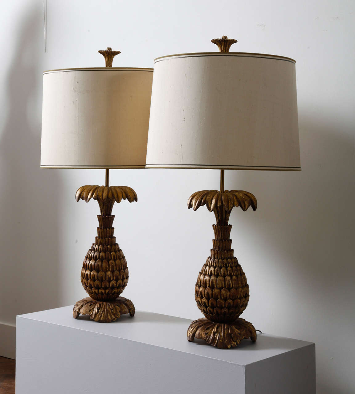 Pair of decorative two light table lamps with a gilt wooden base in the shape of a pineapple. A lampshade in wild silk fabric is arranged on the brass mainstay and a power cord under the base. 
		
Total H. 38.98 inches (99 cm); pineapple base H.