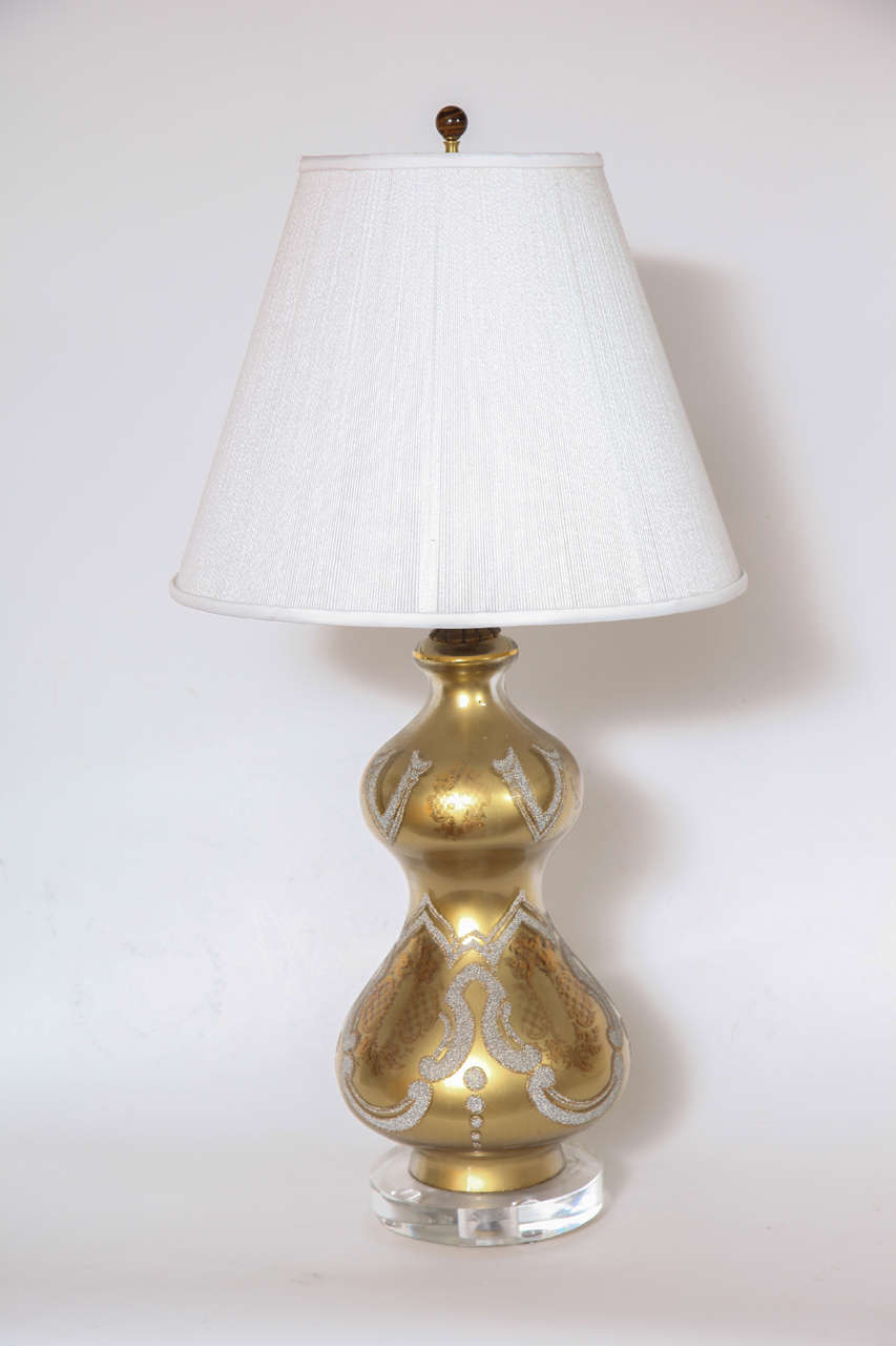 A great pair of eglomise lamps with white stippled design over a subtle crest designs on lucite bases.