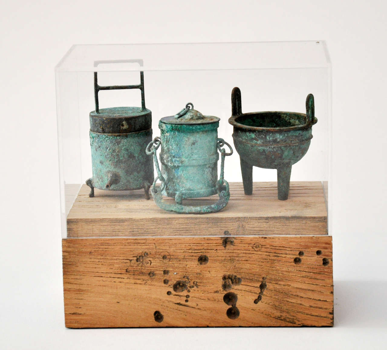 Collection of 20th century Chinese bronze miniatures in a weathered wood or acrylic display. Collection of mini bronze vessels displayed on a weathered wood base with acrylic cover. Fabulous verdigris finishes on bronze vessels.

  