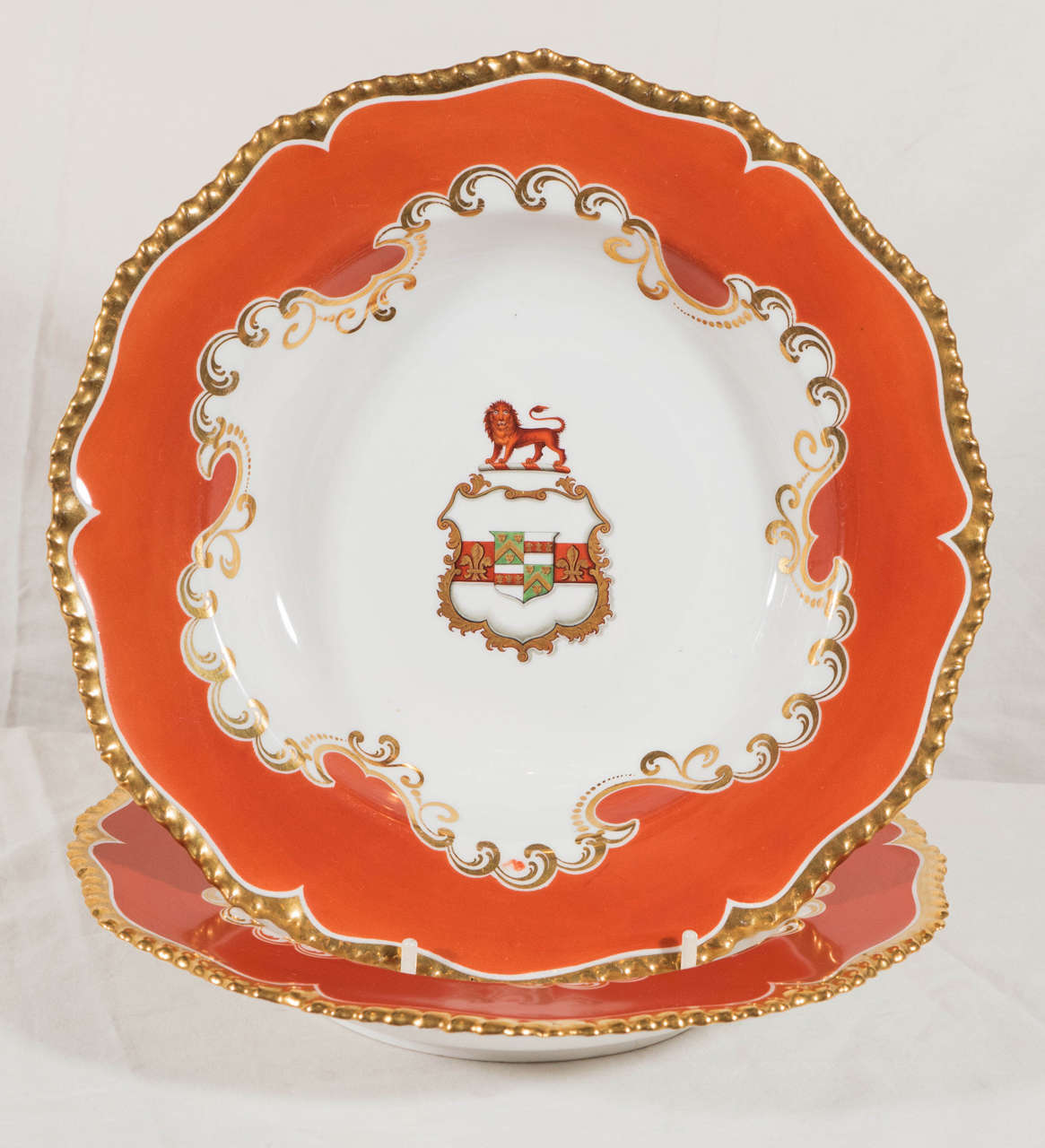 A set of 9 Regency period Chamberlain’s Worcester armorial soup dishes. Created by Chamberlain's Worcester, with other later identical Tiffany replacement pieces. The dishes feature a tomato red border, a gadrooned and gilded edge, and a striking