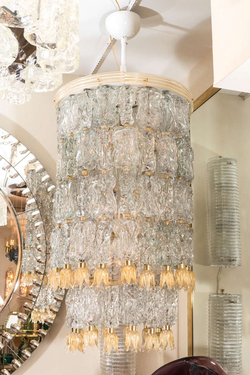 Tiered chandeliers composed of textured clear glass elements with golden glass tulip form details.