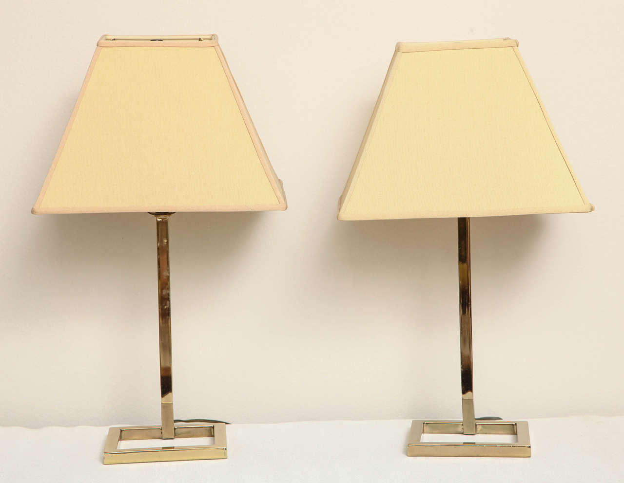 Pair of American brass table lamps with shades, circa 1970. Measurements are for lamp base. Shades are 12