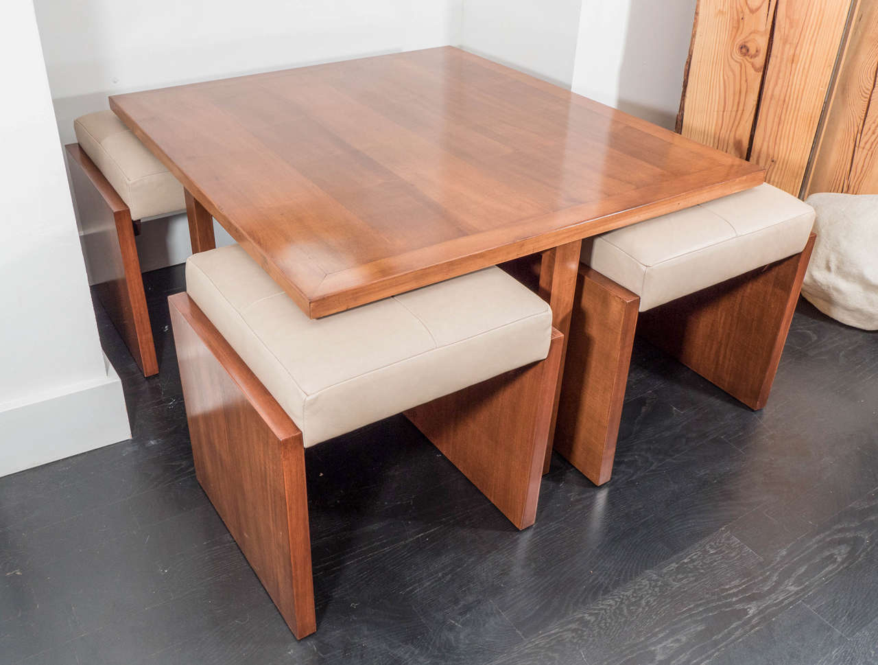 A set of four mahogany benches with leather seats rest under a matching table. Newly upholstered seats and refinished bases. The benches measure H 18