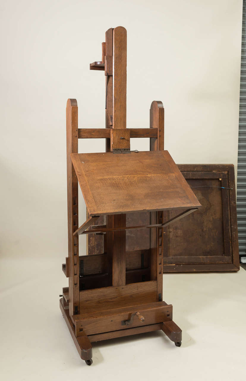 19th Century French artists easel of large proportions. Set on casters with multiple functions of adjusting up, down and tilts out. Folio stand on one side, 28