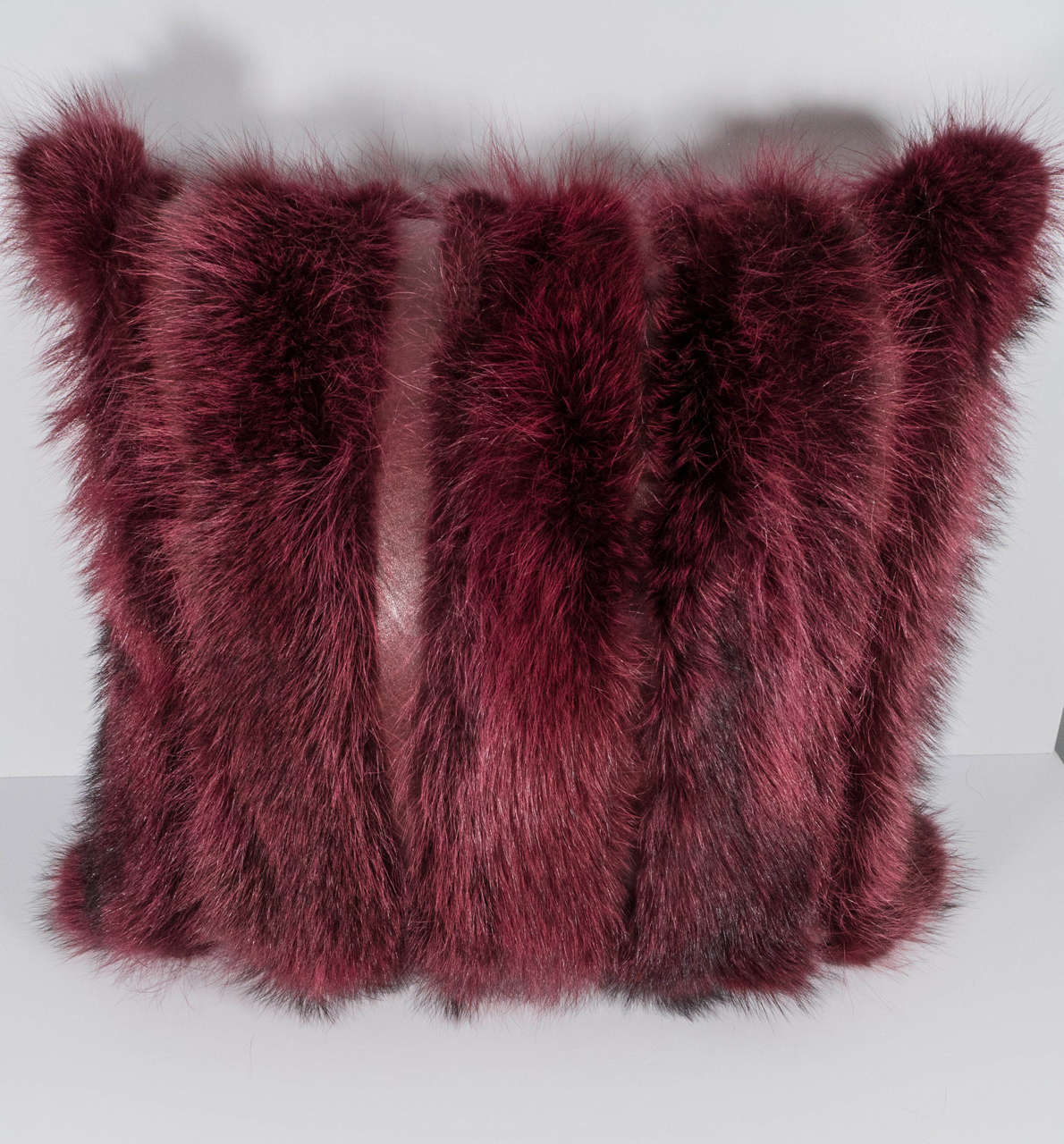 Burgundy long hair fox pillow with leather strips.