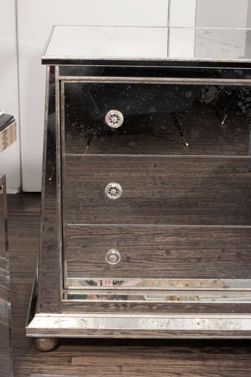 Custom ball foot mirrored commode with silver leaf trim. The one is shown in antiqued mirror finish. Customization is available in different sizes, mirror finishes and hardware.