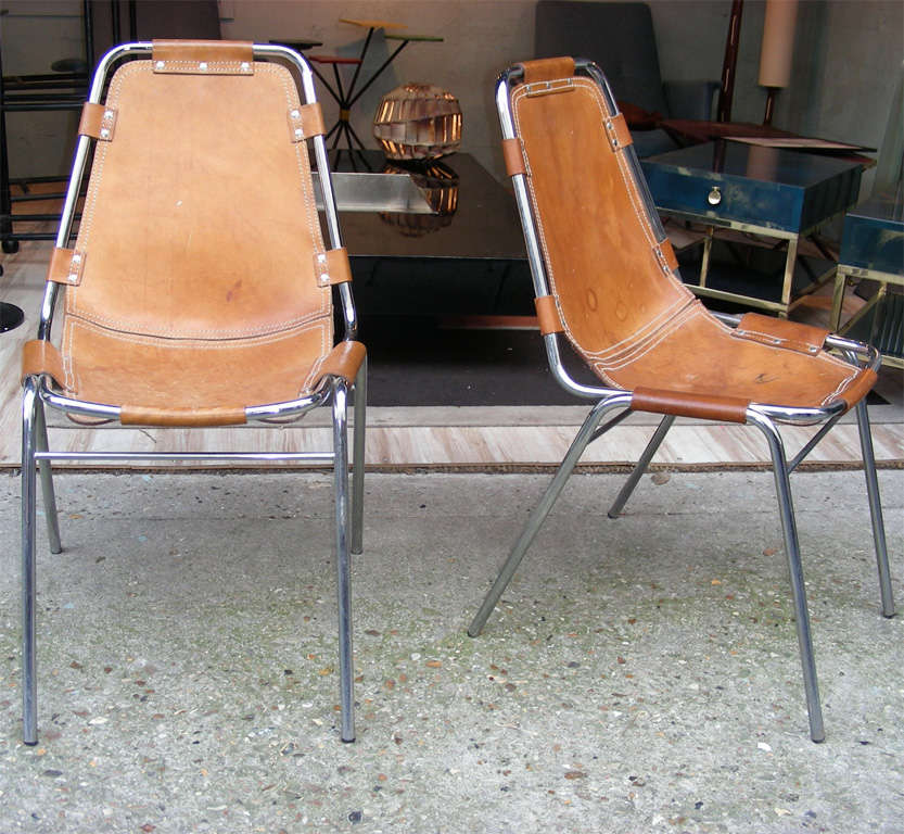 Two 1960s chairs by Charlotte Perriand, in chrome metal and tan leather.