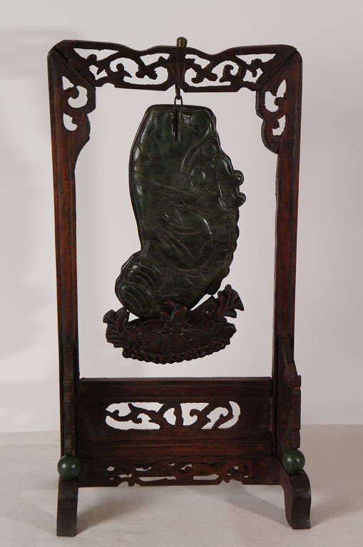 Cette plaque de jade néphrite sculptée d'un animal mythique présente les attributs d'un dragon et d'un poisson bondissant hors de l'eau. Sculptée, selon nous, à la fin du XVIIIe ou au début du XIXe siècle pour servir d'insert à un meuble ou à un