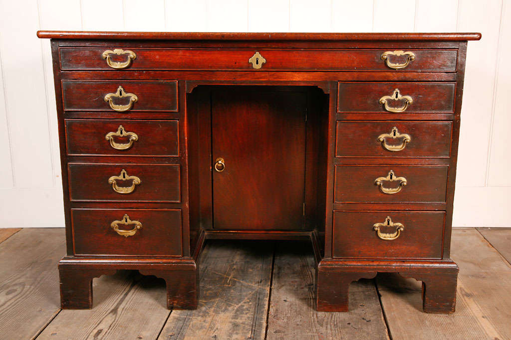 A superb George II knee hole desk from Wentworth Woodhouse with rectangular top above nine frieze drawers around a central knee hole on bracket feet.