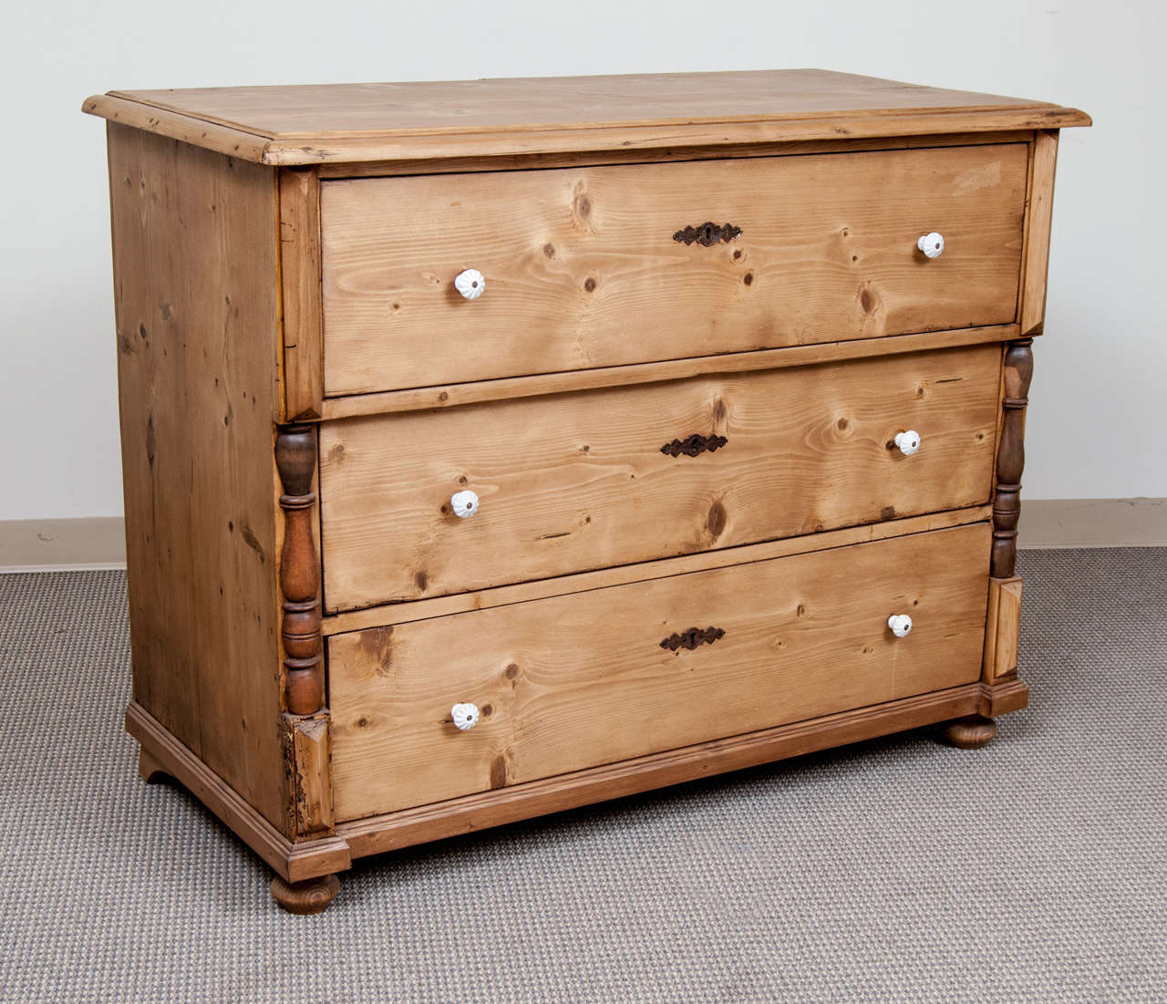 A handsome three drawer chest of very nice colour featuring original ceramic knobs and beechwood split balusters.