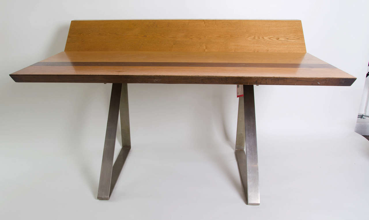 An Italian ash and stainless steel desk designed by Giovanni Offredi, circa 1970. Produced by Saporiti, Italy, ash and stainless steel, the top with a pencil tray.<br />
33.1/4 in. (84.4 cm.) high; 55 in. (139.7 cm.) wide; 33 in. (83.7 cm.) deep;