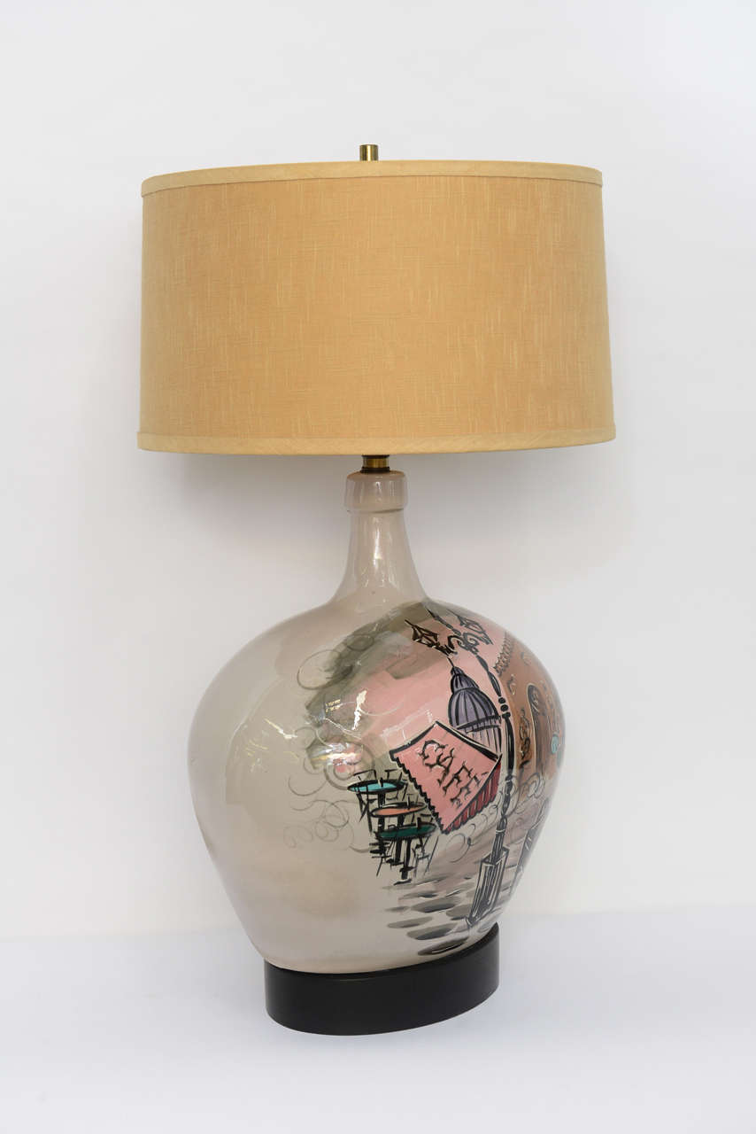 REDUCED FROM $850.....Grand scale with this charming, 1950s bulbous pottery table lamp with an underglaze painted Parisian scene. Illegibly signed, it features the Arc de Triomphe, Sacre Coeur, a street cafe and the Eiffel Tower and more. A tree on