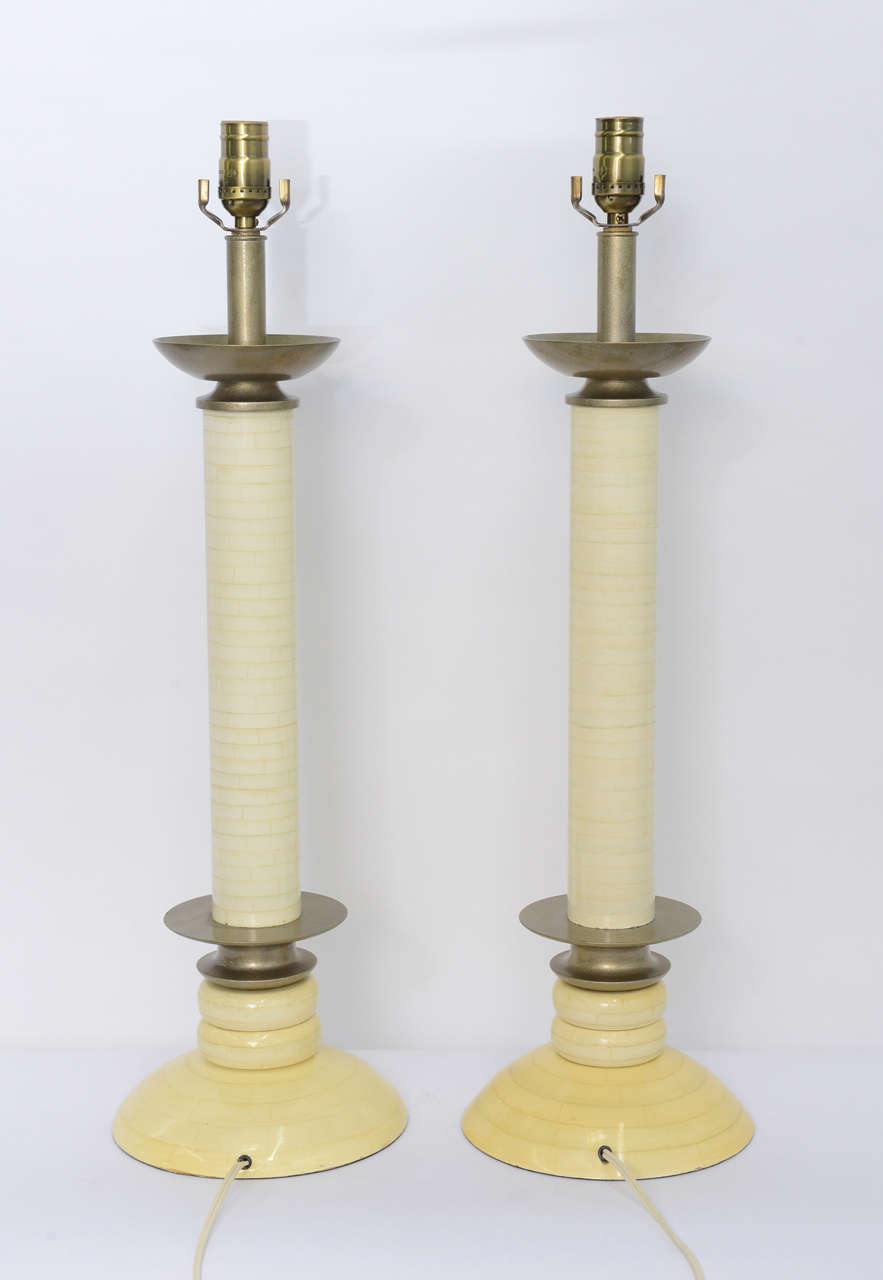 Elegant columnar candlestick lamps featuring beautiful incredibly realistic faux painted tessellated bone or ivory finish. Upper and lower bobeche styling in bronze tone. Rewired and with new UL antique brass three way sockets. Just add your