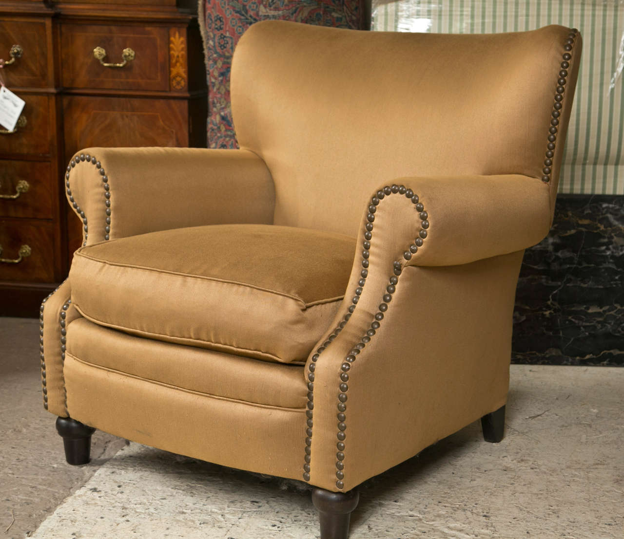 Pair of Overstuffed Oversized Arm Lounge Chairs. These custom quality armchairs having solid mahogany feet leading to brass tacked design arms and flowing sides. The upholstery of a satin look extremely comfortable.