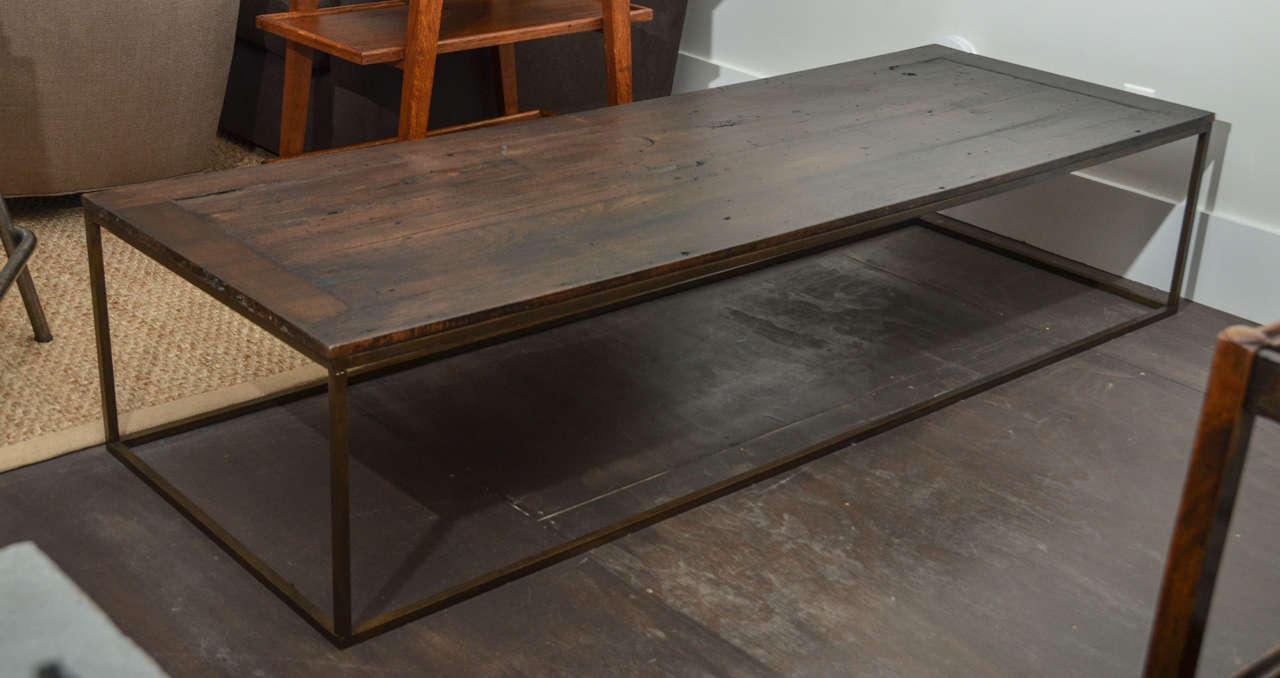 Long wooden coffee table made of Antique Chestnut Top and Contemporary solid Bronze Base.